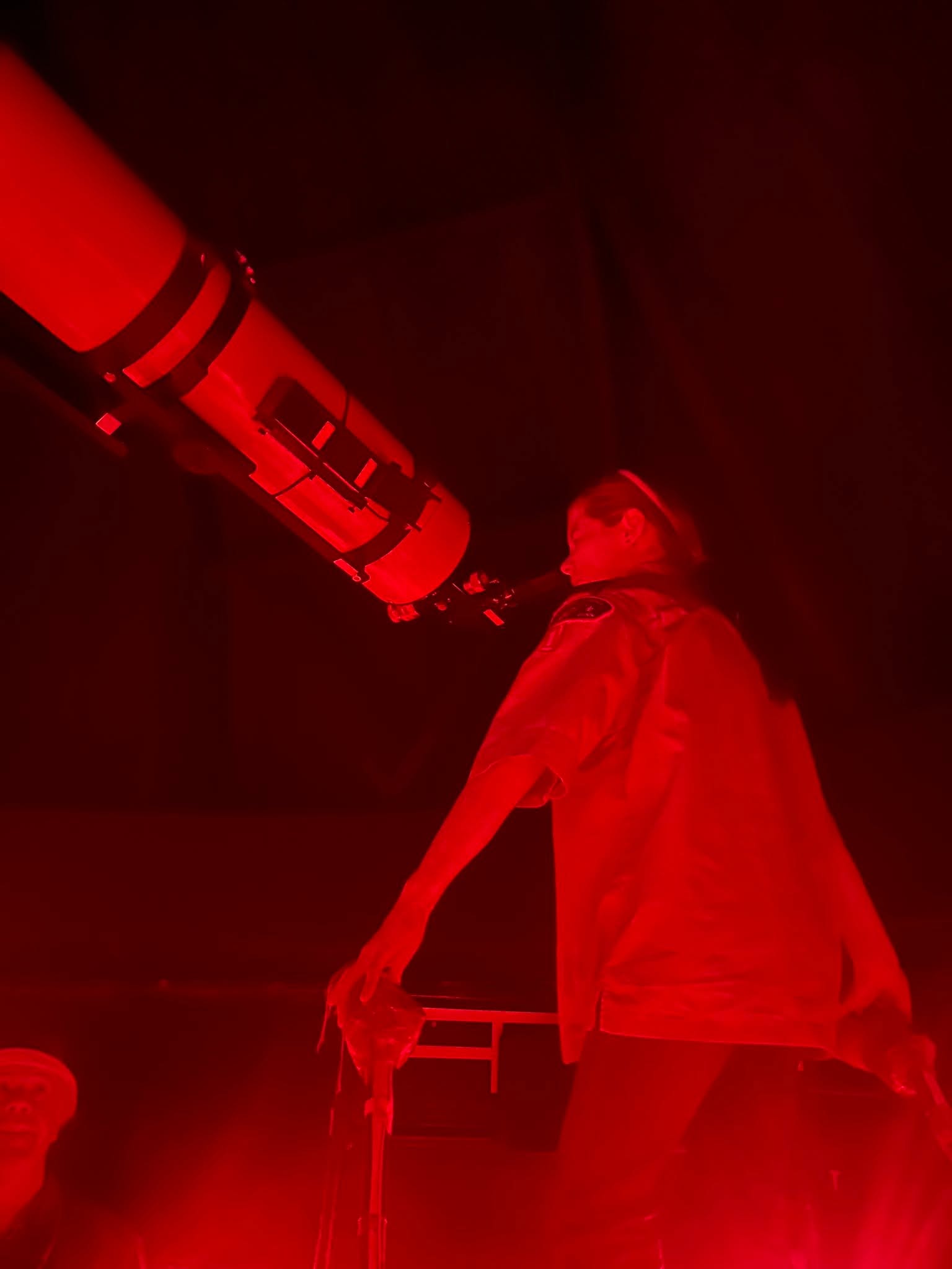 A Troop 33 Scout exploring the night sky through a telescope